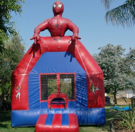 Red and blue Spider-Man-themed inflatable bounce house with netted entrance outdoors