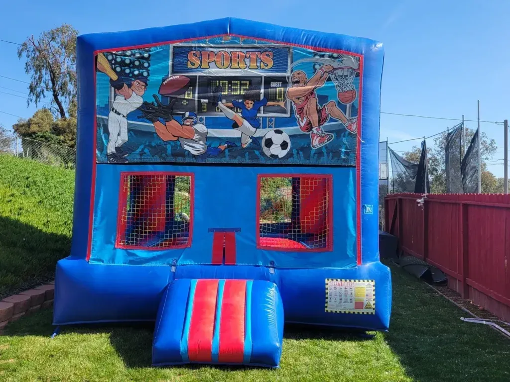 Blue inflatable sports bounce house with soccer and basketball graphics on grass outdoors
