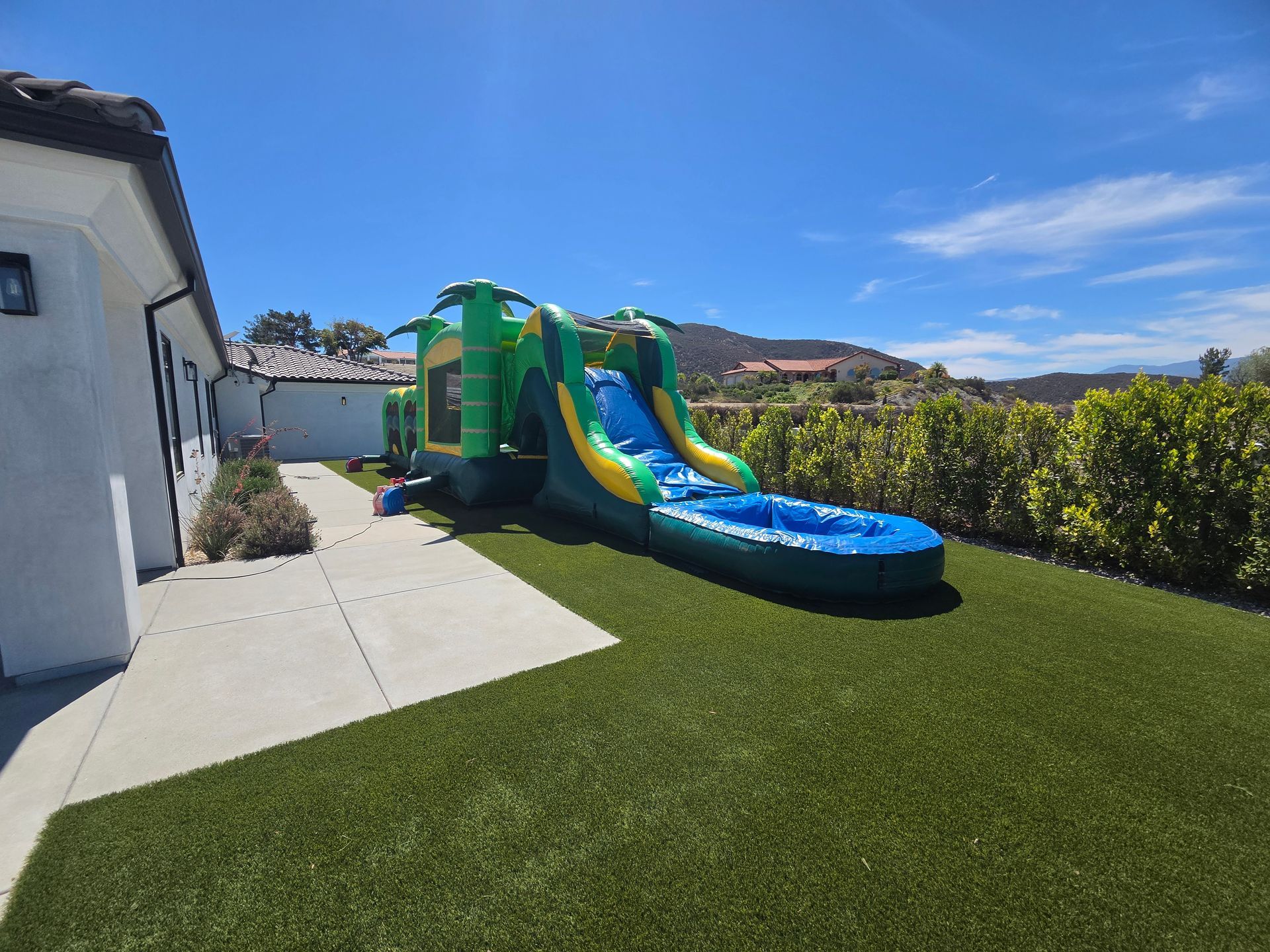A large black inflatable tent is sitting on top of a lush green field.