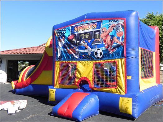 Colorful Spider-Man inflatable bounce house with slide in a sunny yard