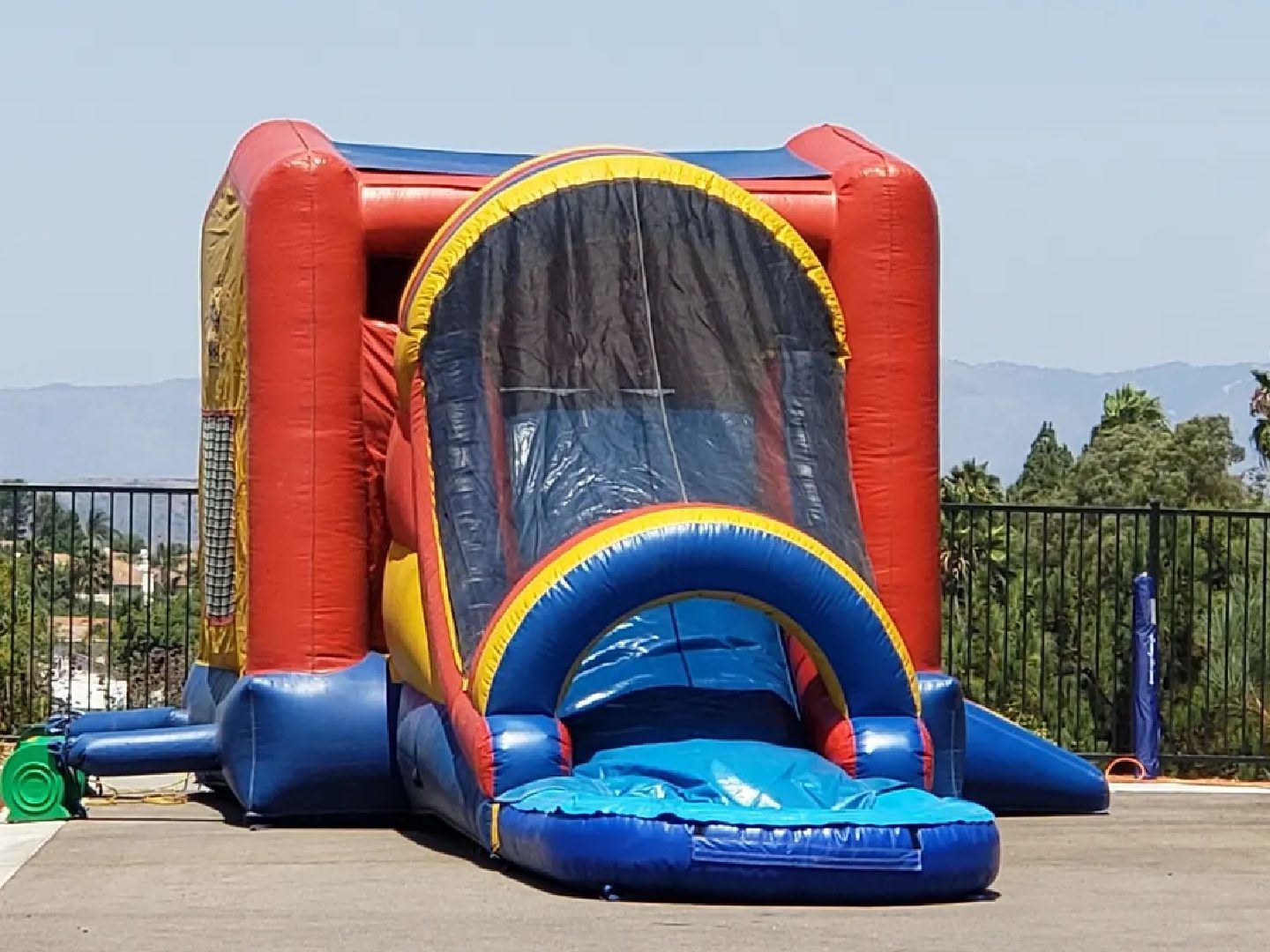 Colorful inflatable bounce house with slide on a sunny outdoor playground