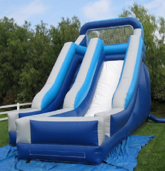 Blue-and-white inflatable water slide on grass outdoors under a sunny sky