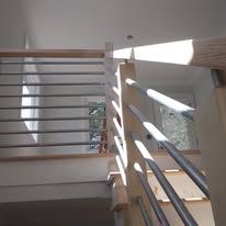 Sunlit stairwell with metal railings and bright shadows on the wall