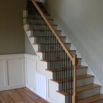 Wooden staircase with white railing and wainscoting in a home interior