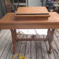 Wooden table with a small tray on top, sitting on a weathered porch