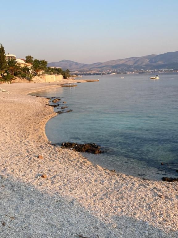 Ein sandiger Strand, der sich bei Sonnenuntergang entlang des ruhigen blauen Meeres schlängelt.