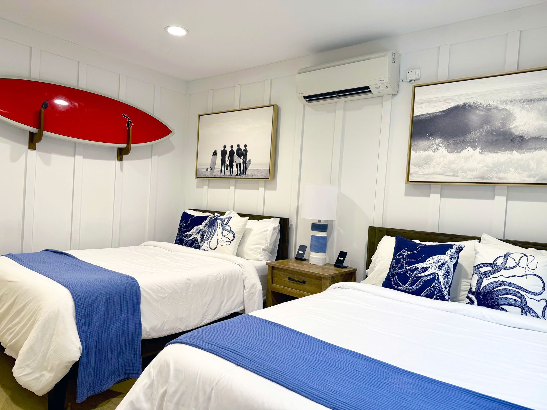 Guest bedroom with blue octopus wall art and coastal pier mural at Newport Retreat