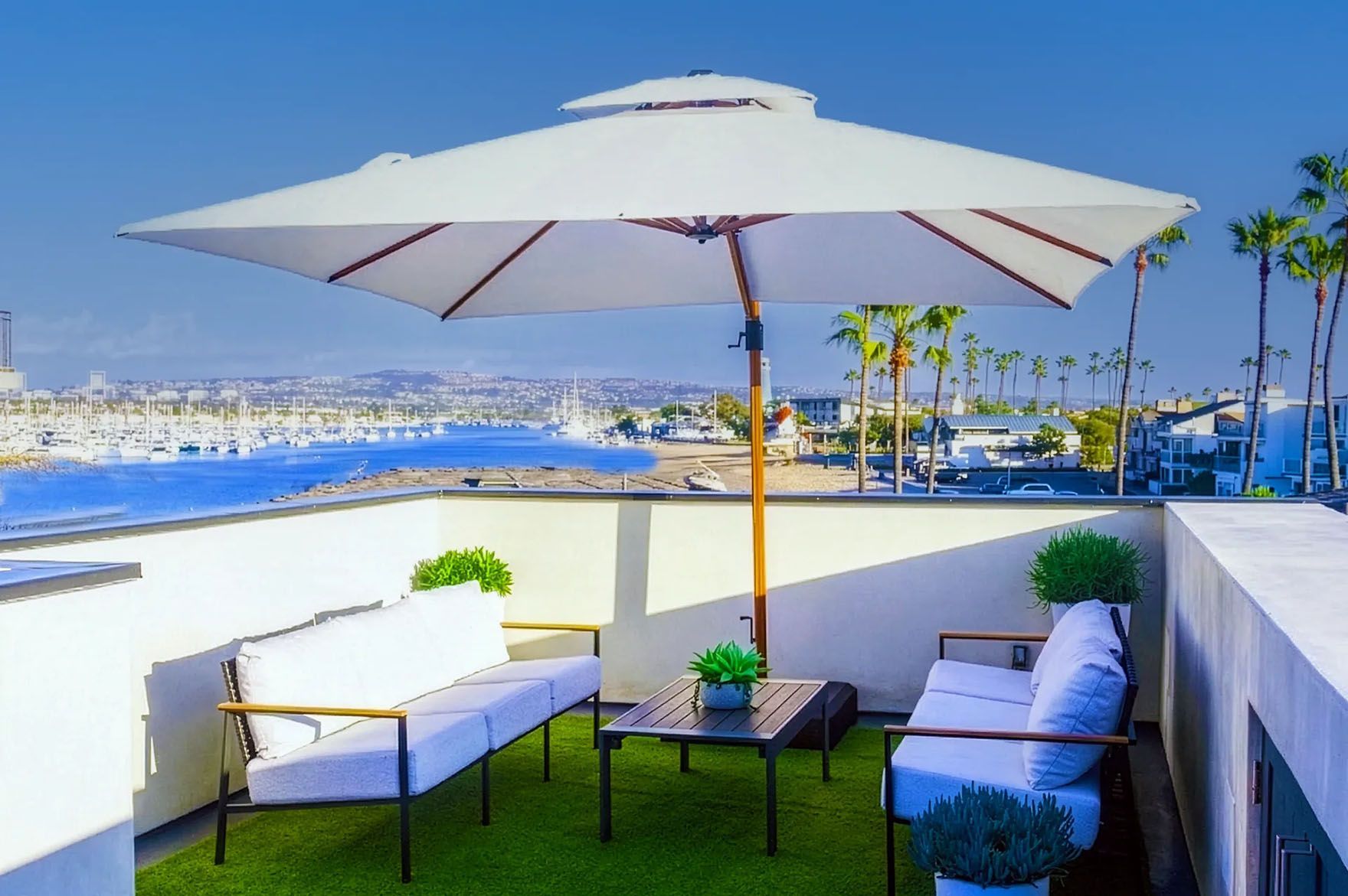 Private rooftop deck with umbrella, lounge seating and Newport Harbor view