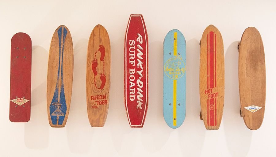 Wall of seven vintage skateboards and surf-brand decks displayed as art at Harbor Lookout
