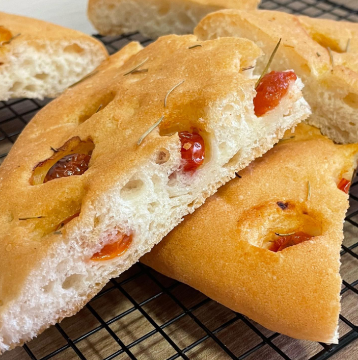 Um pão com tomates está em uma grade para esfriar.