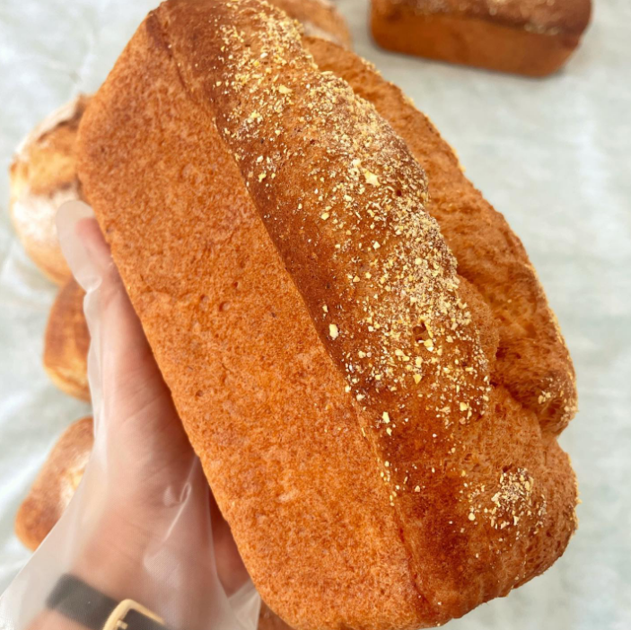 Uma pessoa está segurando um pedaço de pão na mão