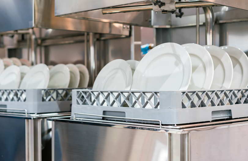Uma máquina de lavar louça cheia de pratos brancos em uma cozinha.