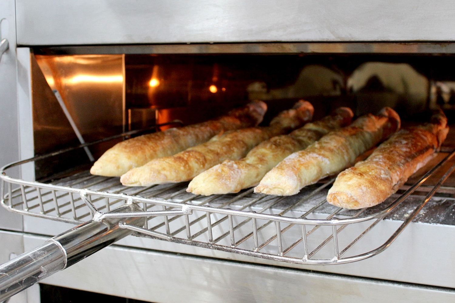 Um monte de baguetes estão assando no forno