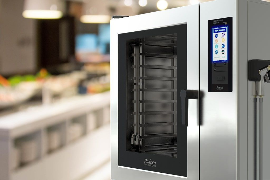 Um forno de aço inoxidável está sobre um balcão em uma cozinha.