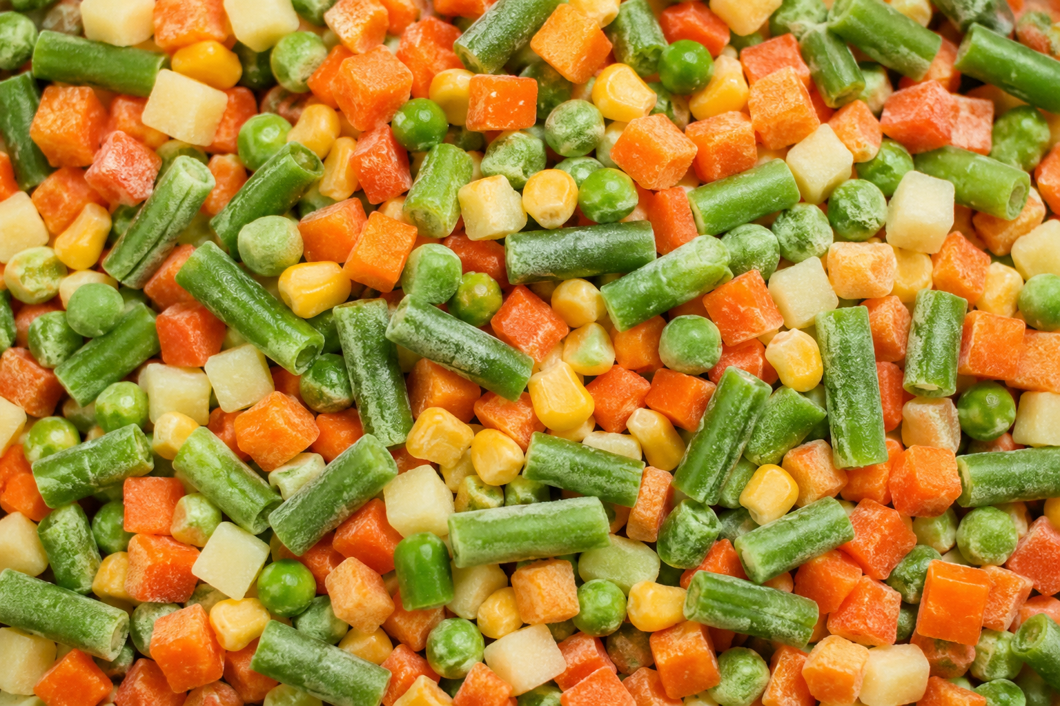 Um close de uma pilha de vegetais congelados.