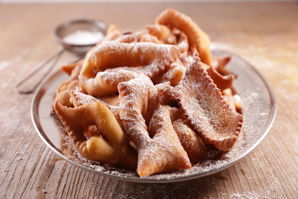 Um prato de comida com açúcar de confeiteiro sobre uma mesa de madeira.