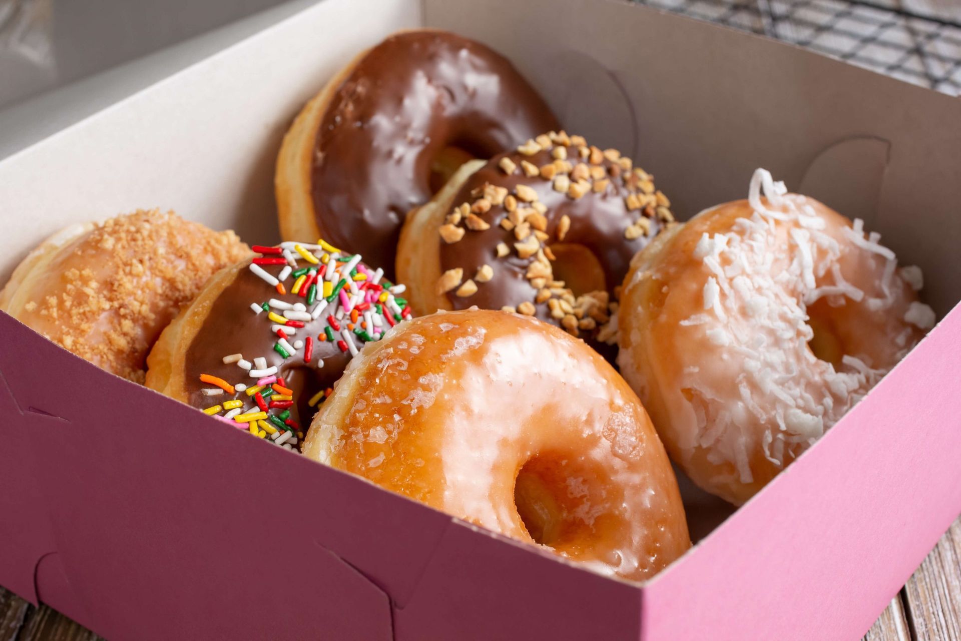 Há muitos tipos diferentes de donuts nesta caixa.