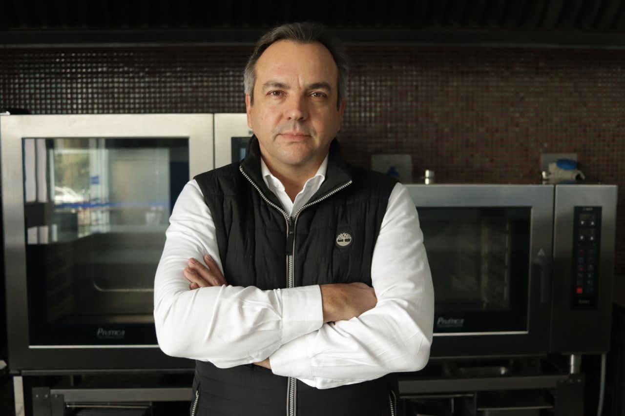 Um homem com os braços cruzados em frente a um forno