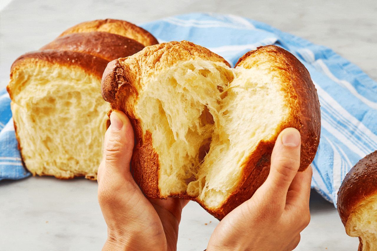 Uma pessoa está segurando um pão nas mãos.