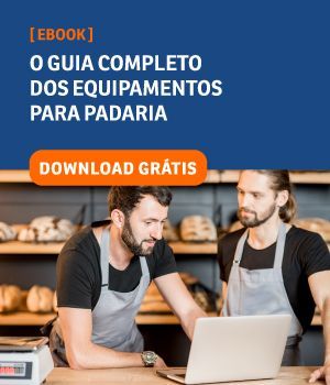 Dois homens estão olhando para um laptop em uma padaria.