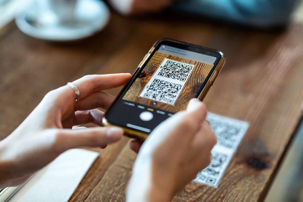 Uma pessoa está tirando uma foto de um código QR em um celular.