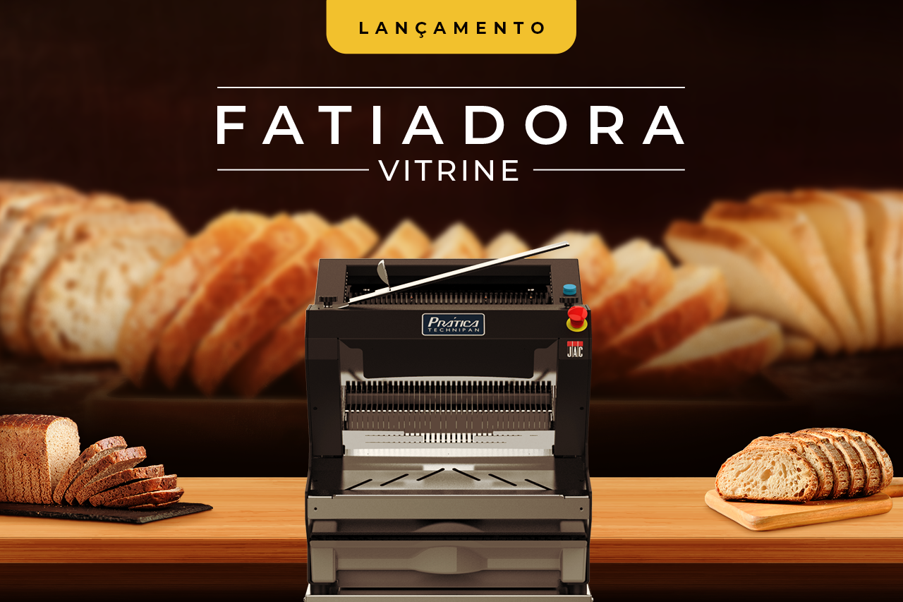 Uma máquina está sobre uma mesa de madeira com pão ao fundo.