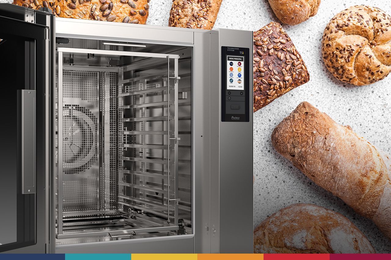 Um forno de convecção está cercado por pães e doces em uma mesa.