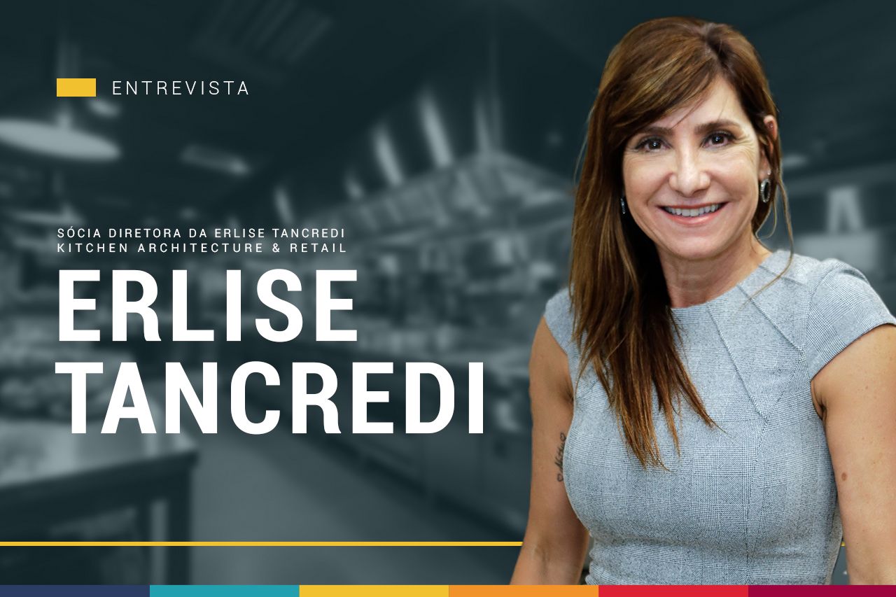 Uma mulher sorri em frente a uma placa que diz erlise tancredi