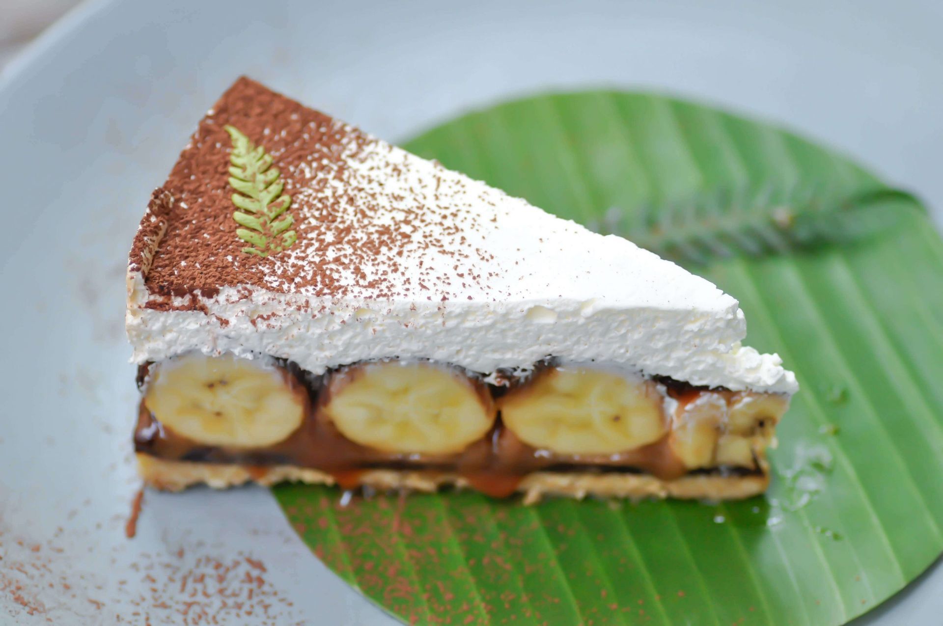 Uma fatia de torta de banana em uma folha de bananeira em um prato