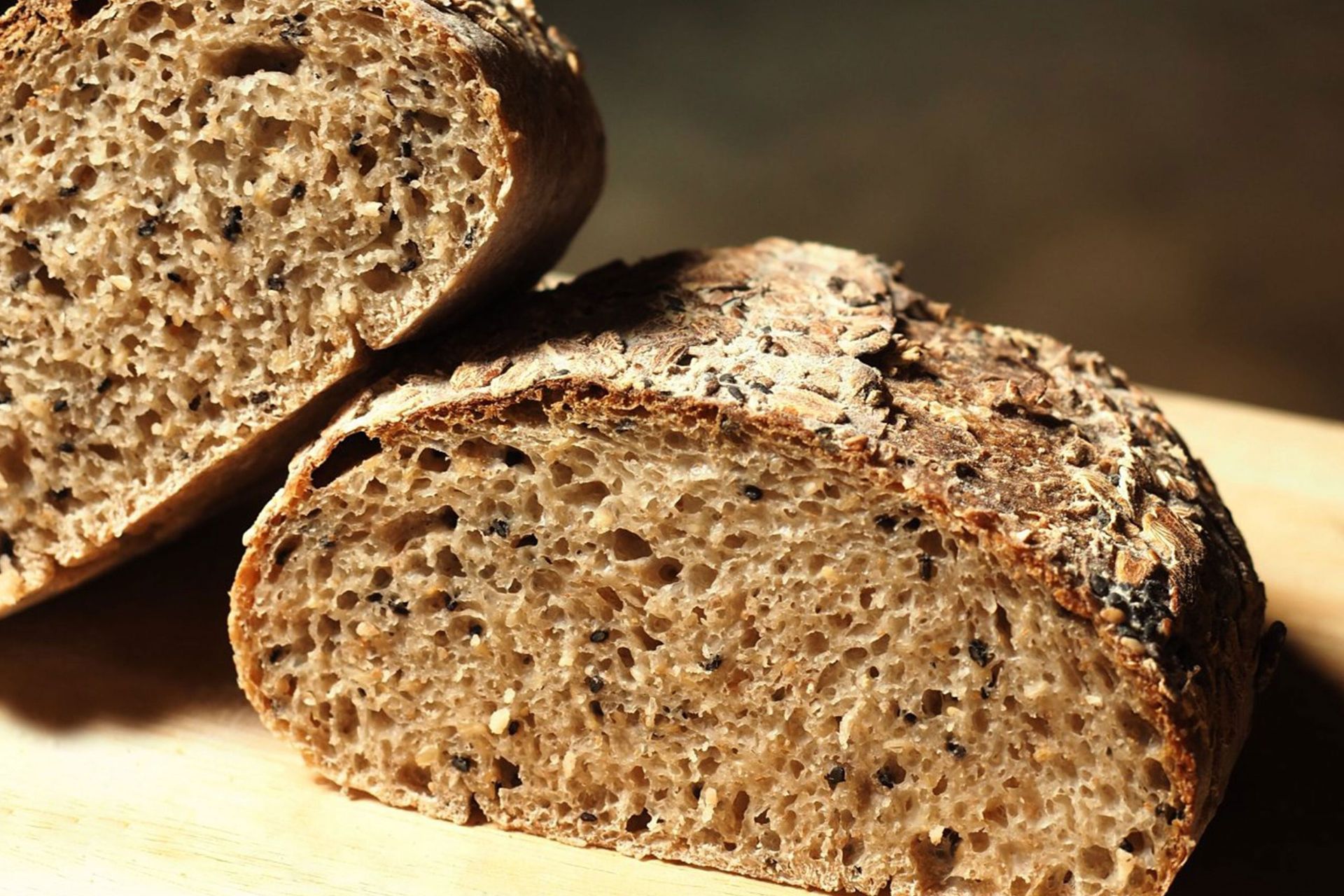 Duas fatias de pão estão sobre uma tábua de corte de madeira