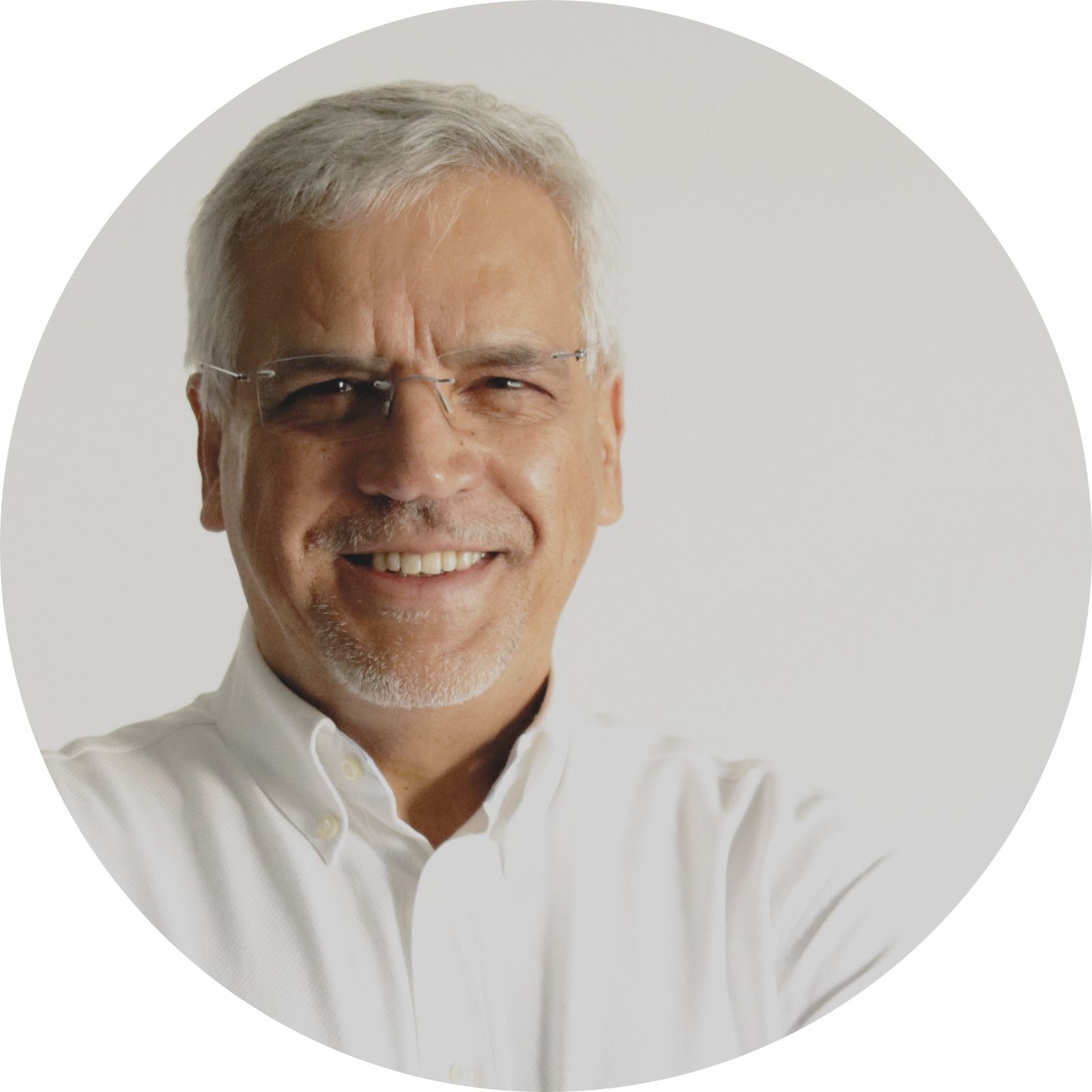 Um homem usando óculos e uma camisa branca está sorrindo em um círculo.