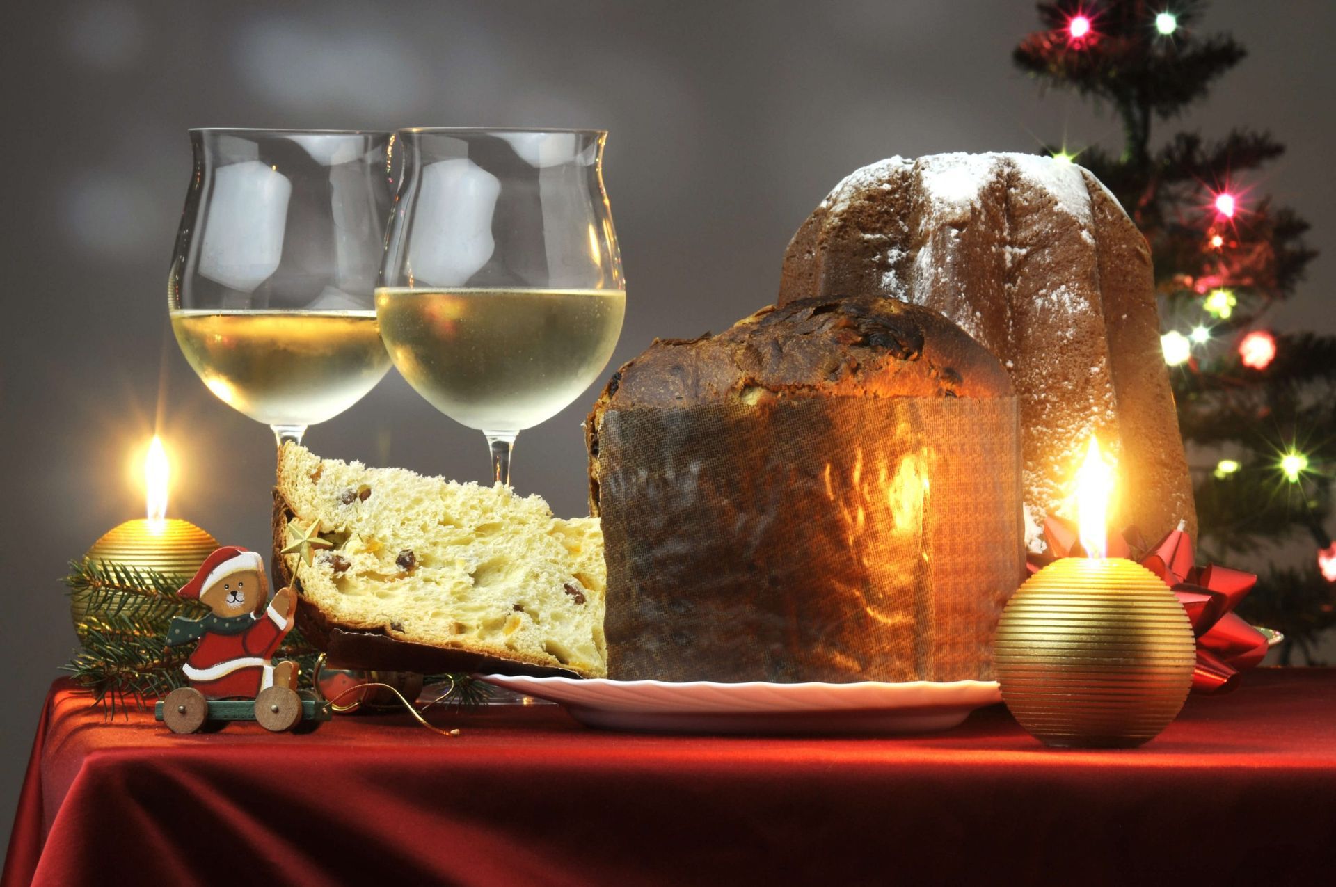 Uma mesa de natal com uma fatia de bolo e duas taças de vinho