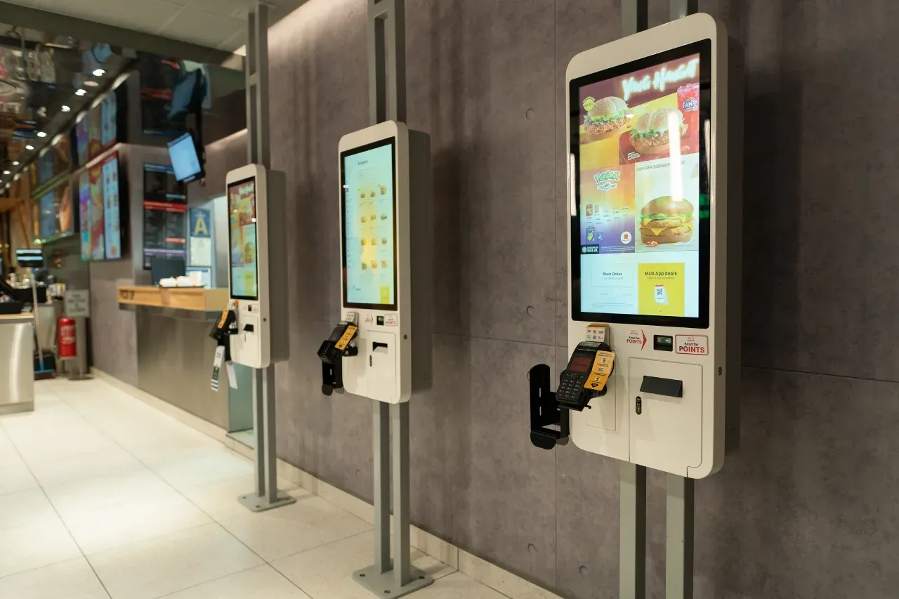 Uma fileira de quiosques de autoatendimento em um restaurante.