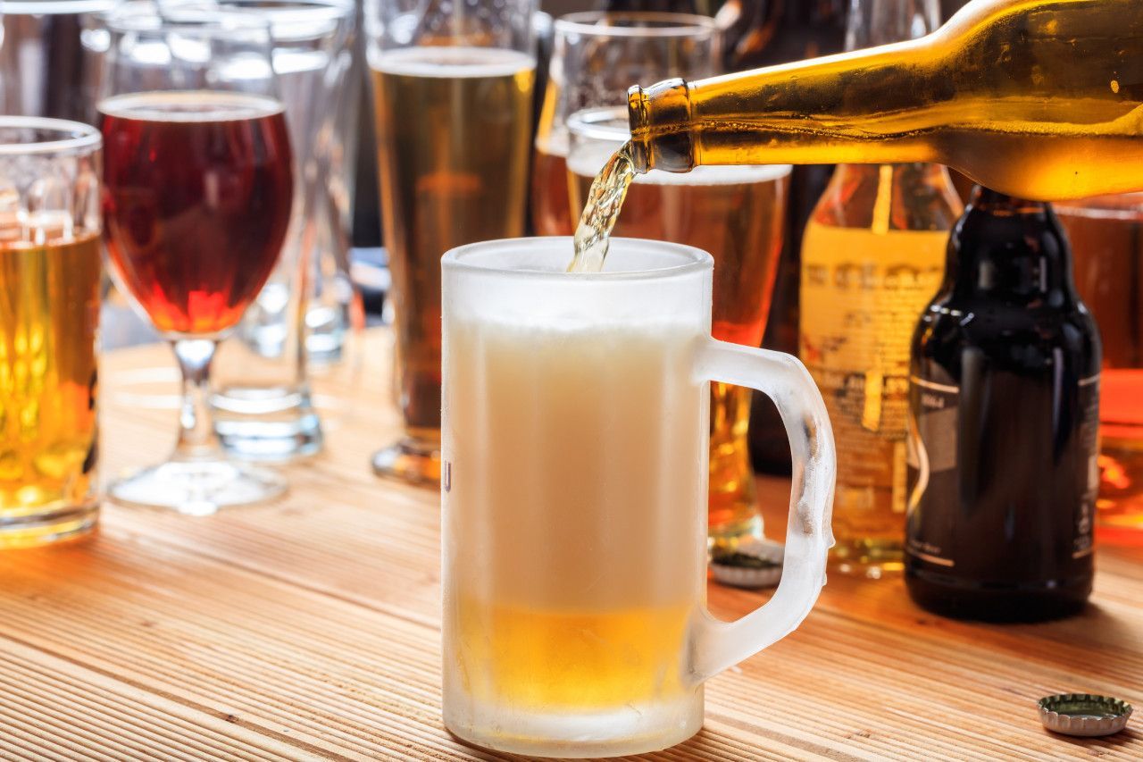 Caneca de chope sendo enchida e canecas cheias de cerveja. 