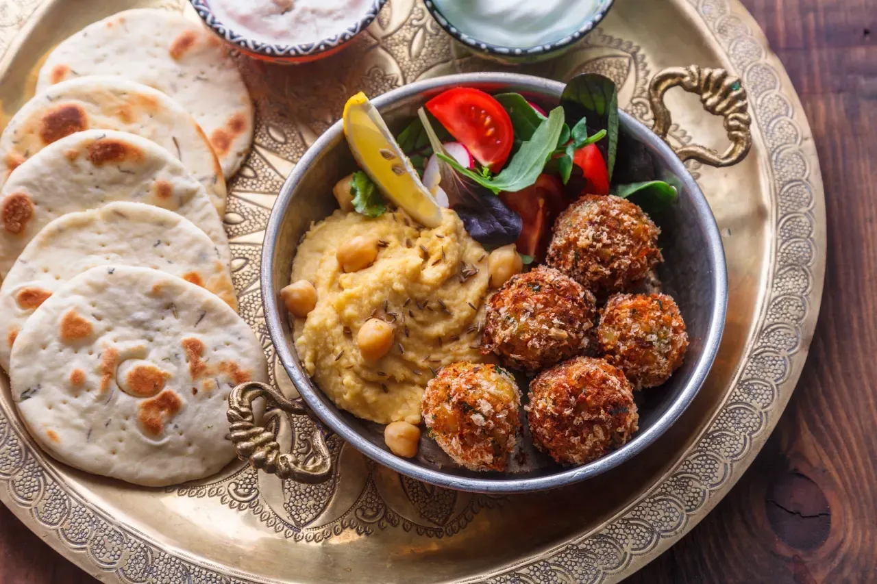 Prato com falafel, homus, salada e pães.