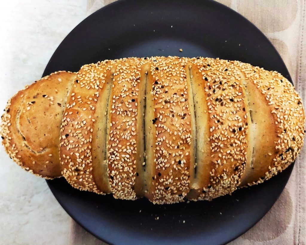 Um pão de gergelim em um prato preto