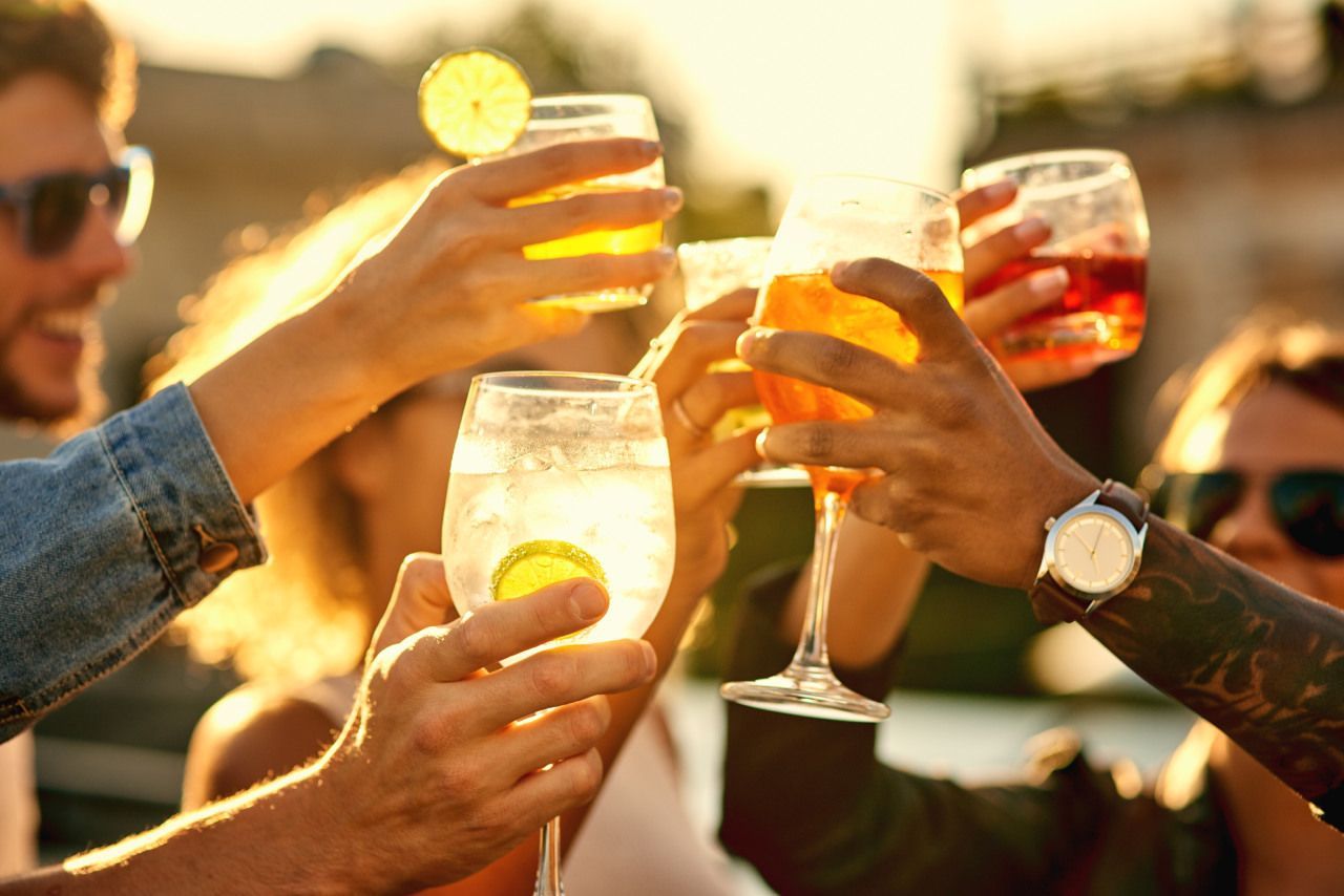 Um grupo de pessoas está brindando com suas bebidas.
