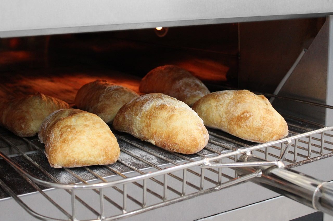 Um monte de pãezinhos estão cozinhando no forno
