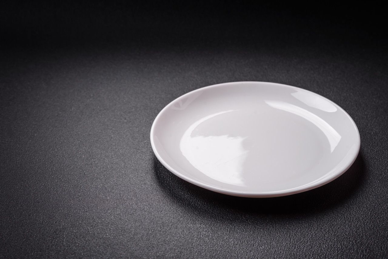 Um prato branco está sobre uma mesa preta.