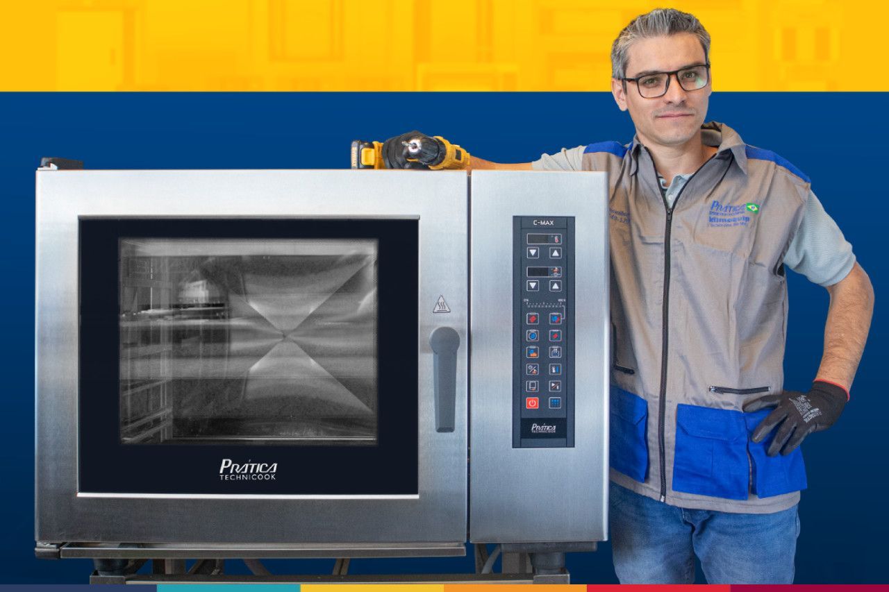Um homem está de pé ao lado de um forno de aço inoxidável.
