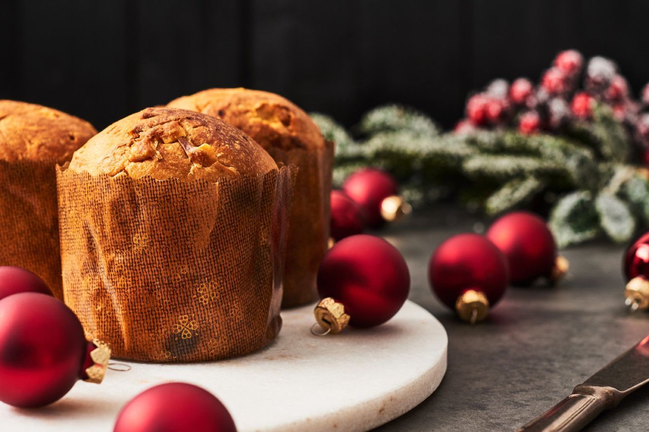 Uma tábua de corte de mármore coberta com cupcakes e decorações de Natal.