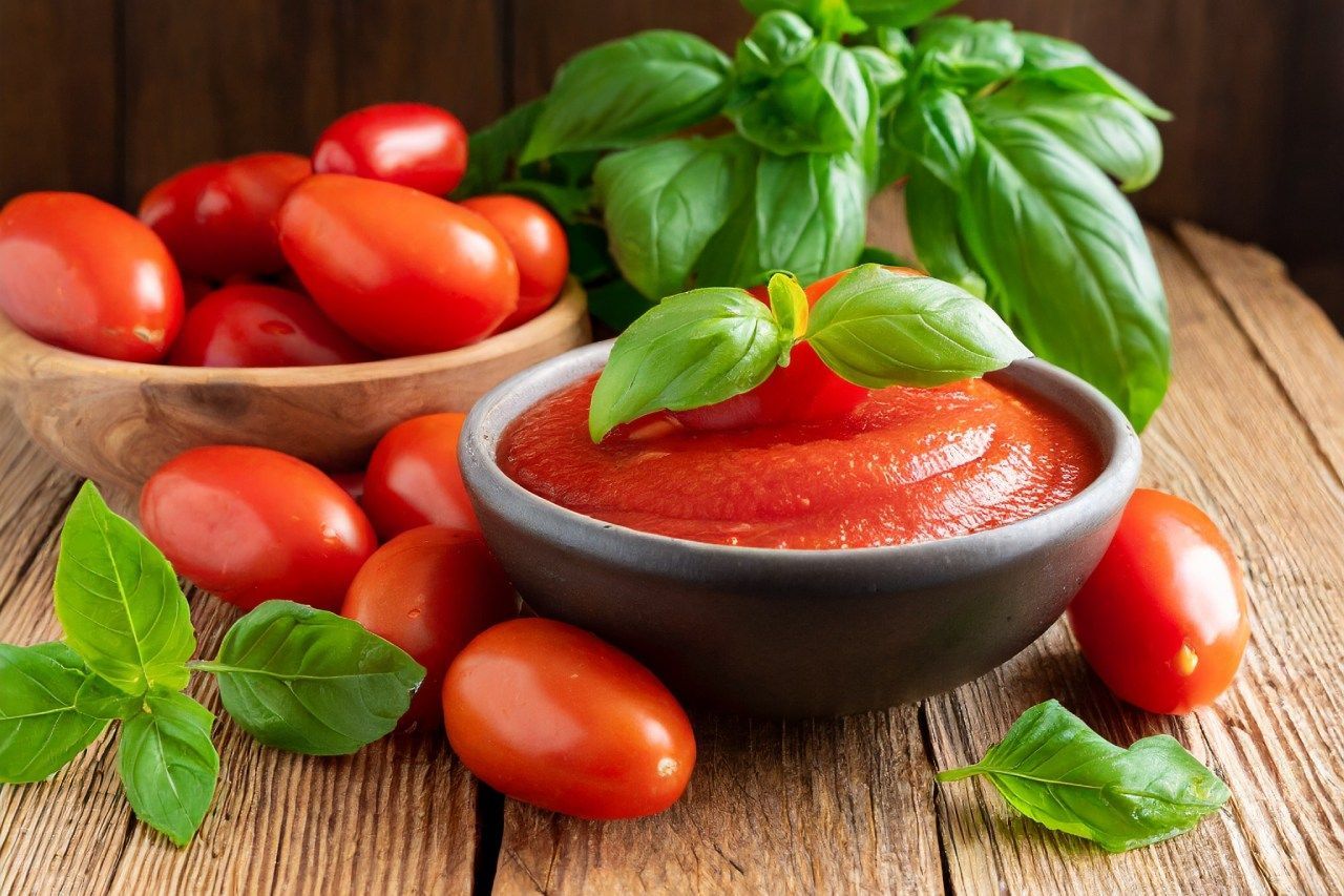 Uma tigela de molho de tomate ao lado de uma tigela de tomates