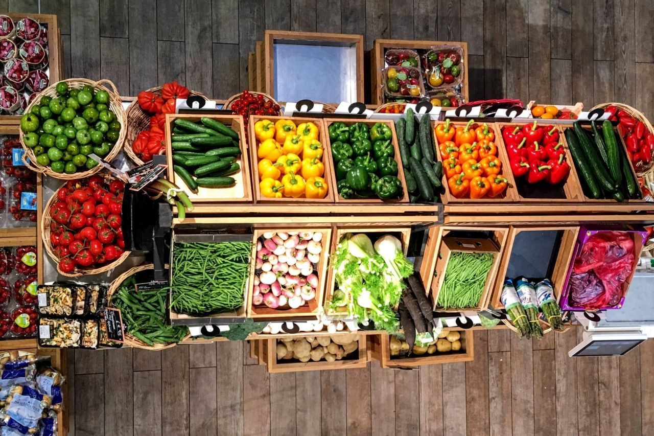 Uma exposição de frutas e vegetais em uma mesa de madeira