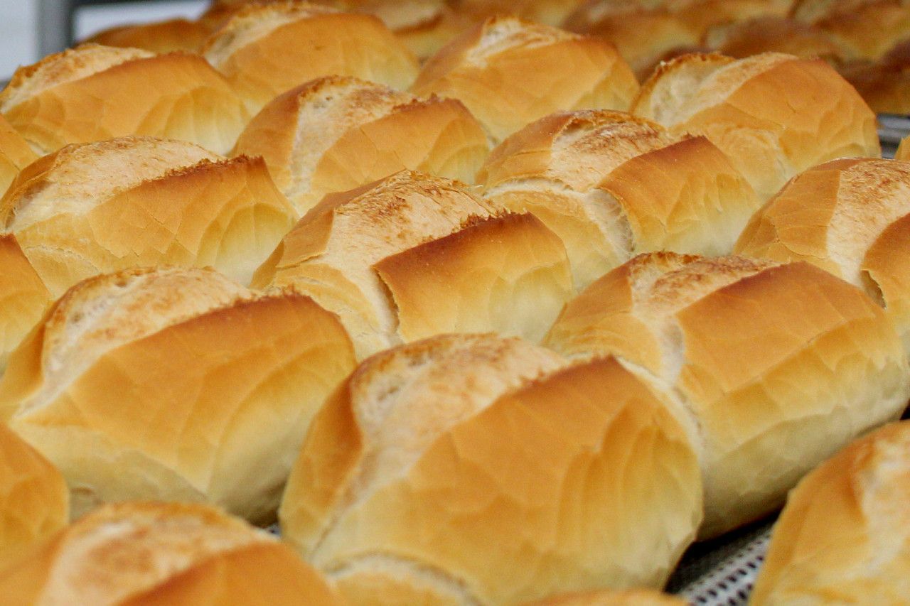 Um monte de pãezinhos franceses estão em uma assadeira.