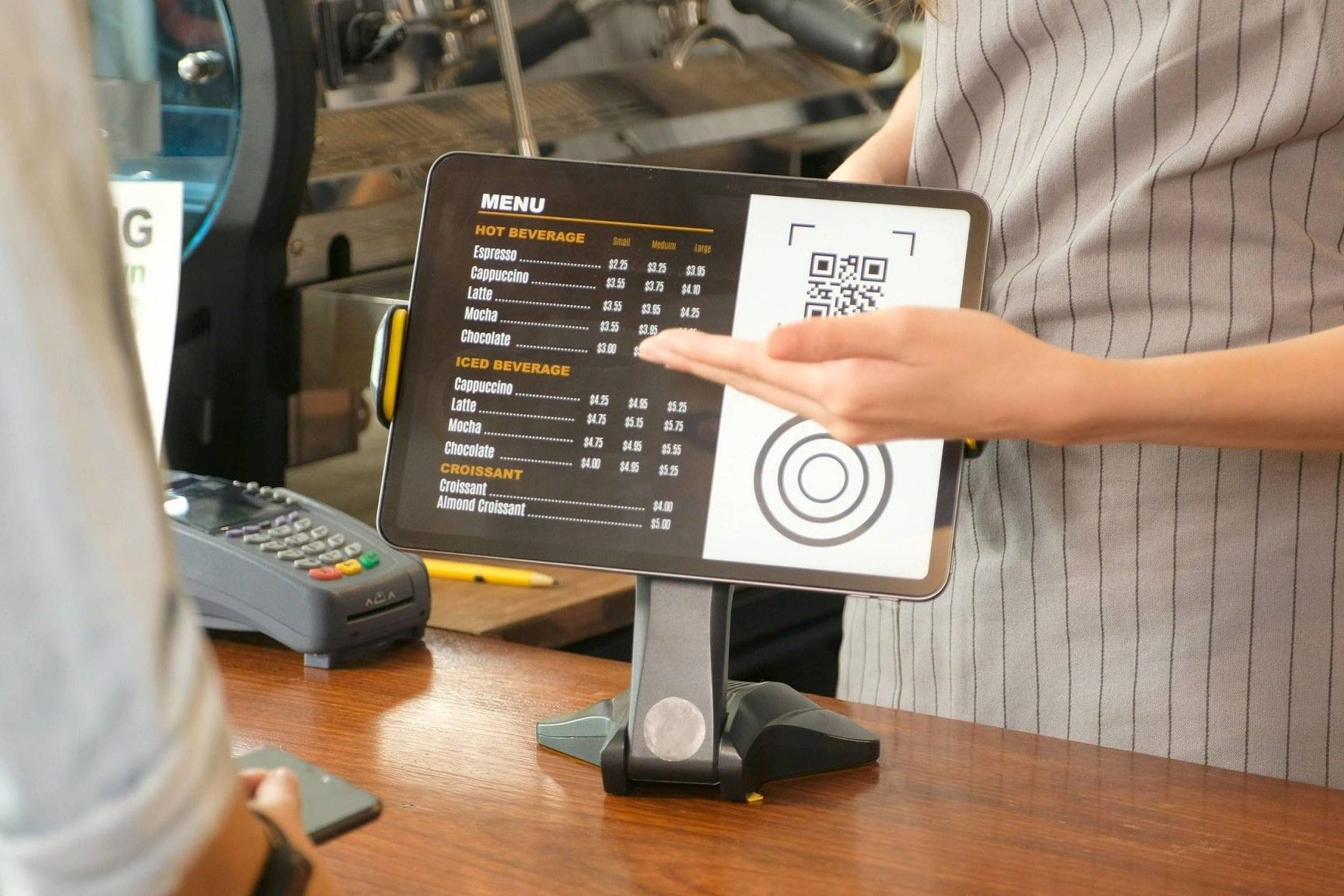 Uma pessoa está segurando um tablet com um menu nele.