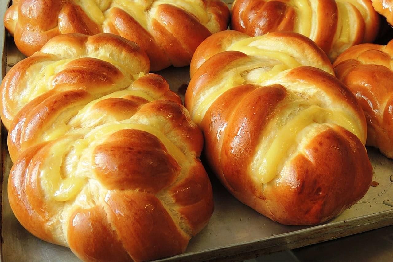 Um monte de pãezinhos estão em uma bandeja sobre uma mesa
