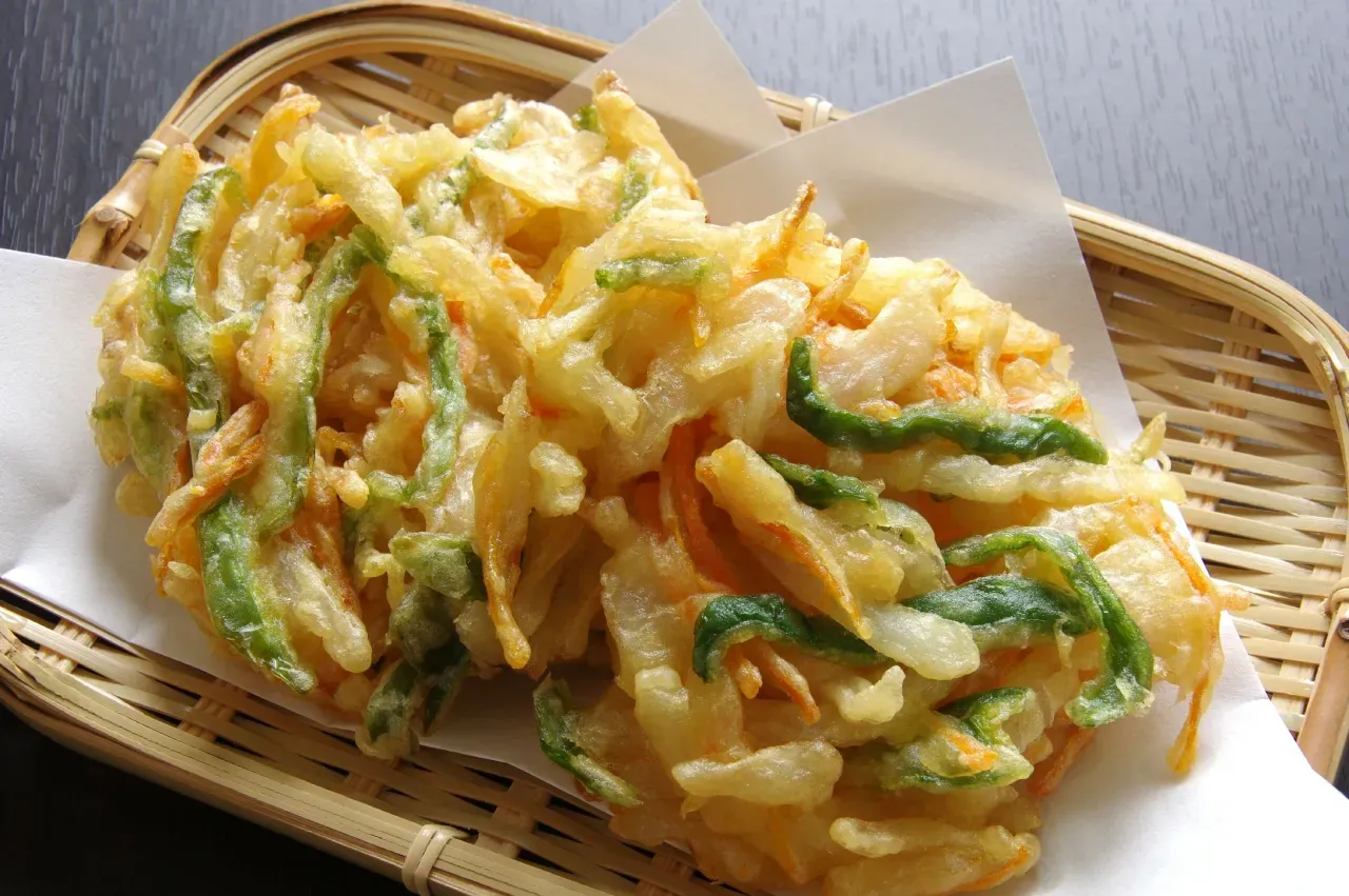 Dois vegetais fritos em uma bandeja de bambu sobre uma mesa.