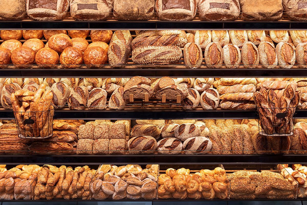 Uma vitrine de padaria cheia de vários tipos diferentes de pão.