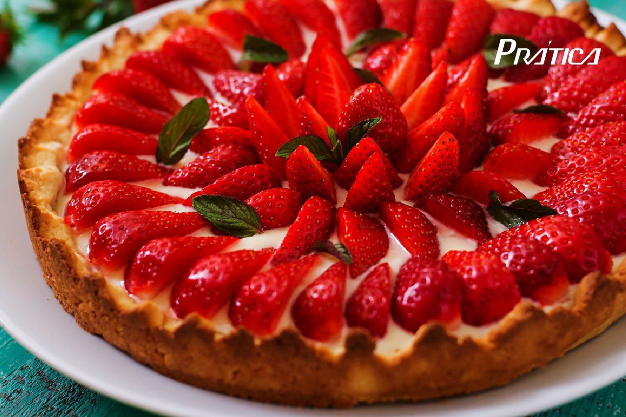 Um prato branco coberto com uma torta de morango