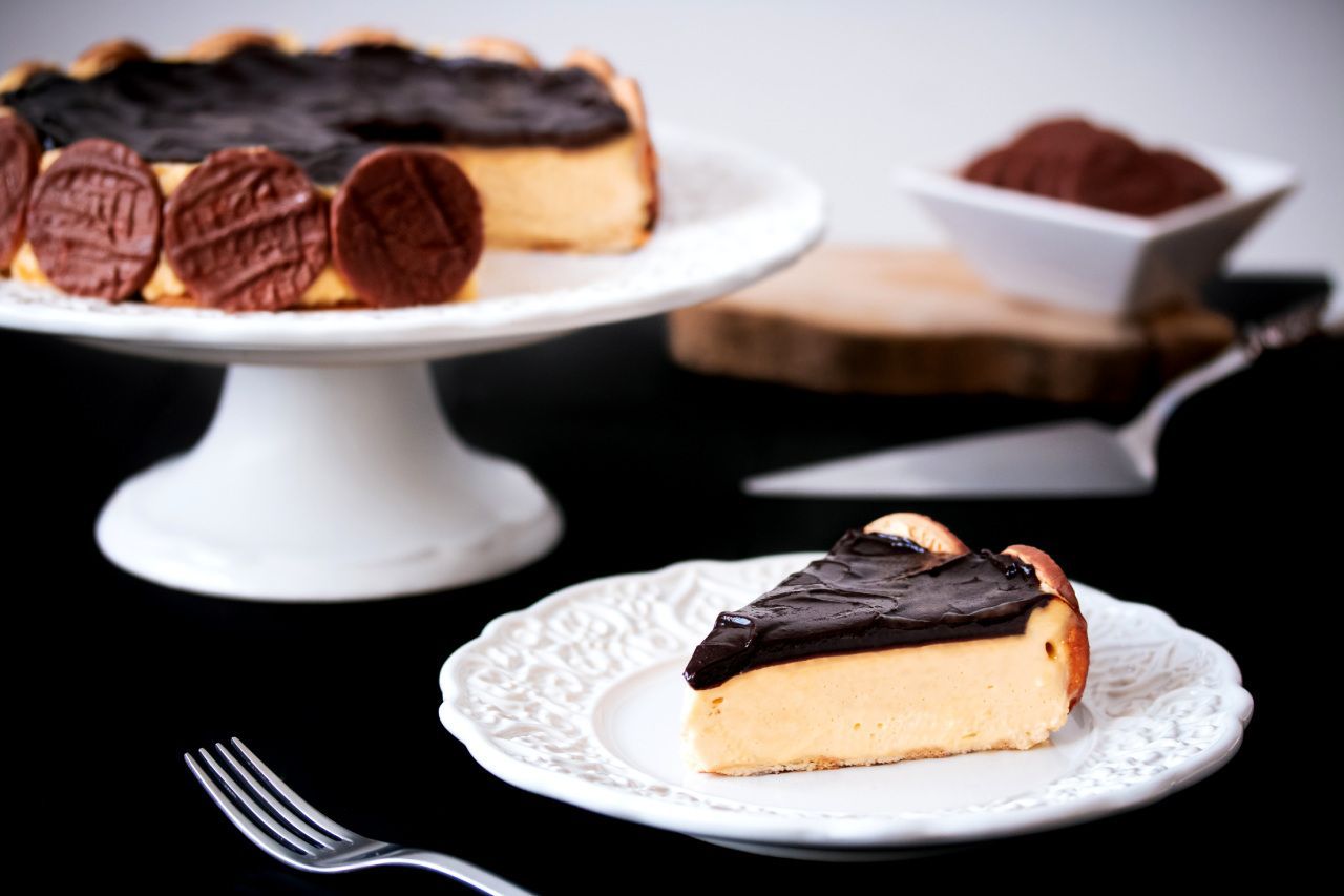 Uma fatia de cheesecake em um prato branco com um garfo